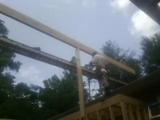 Carpenter setting a ridge beam over a new addition frame — Ice Dam Removal by Roofing Brothers in Manti