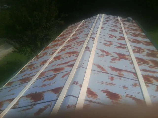 Rusted metal roof panels with new wood purlins before replacement — Storm Damage Roof Repair in Manti by Roofing Brothers