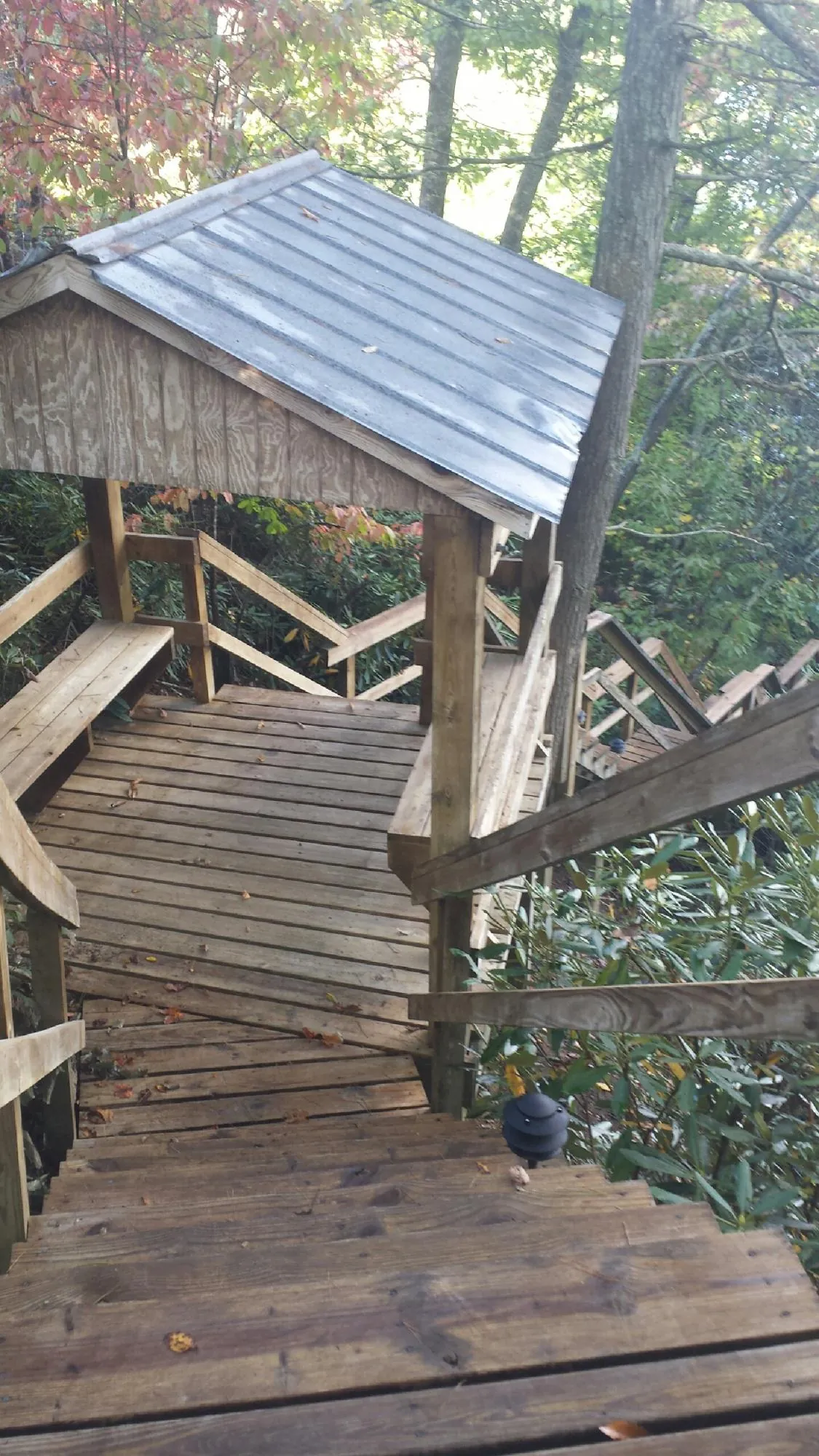 Metal roofed shelter over wooden steps on a wooded walkway — Skylight Repair & Installation work by our crew in Manti