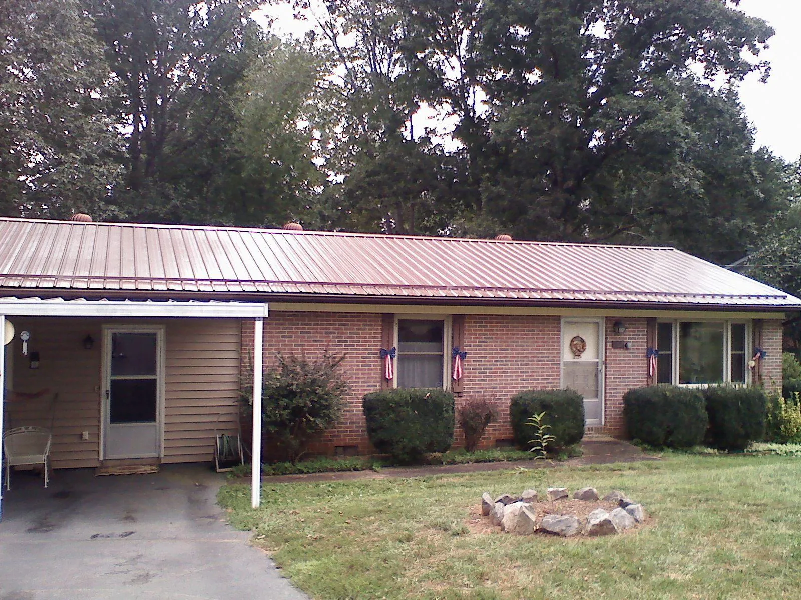Bronze metal roof and carport on a brick ranch home — Roof Repair work by our crew in Manti